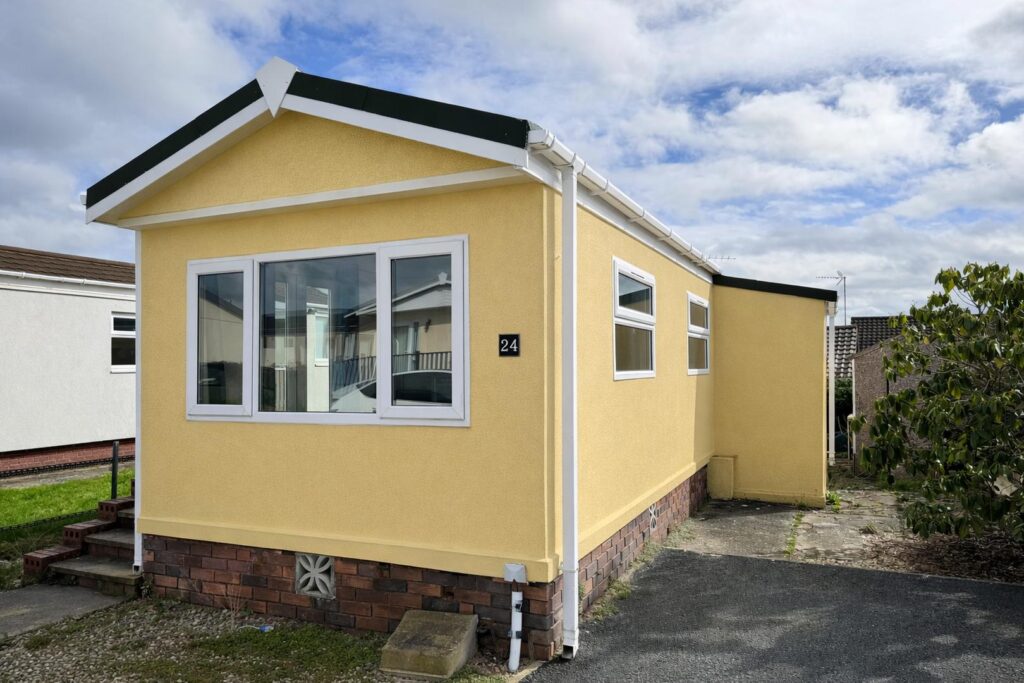 Yellow park home in peaceful setting