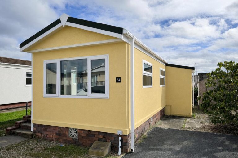 Yellow park home in peaceful setting