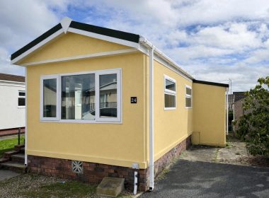 Yellow park home in peaceful setting